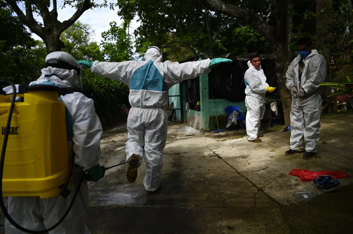 Workers of the Municipal Pantheon disinfect themselves after the burial of an alleged COVID-19 victim, in the municipality of Antiguo Cuscatlan, El Salvador, on June 22, 2020. - The government of El S