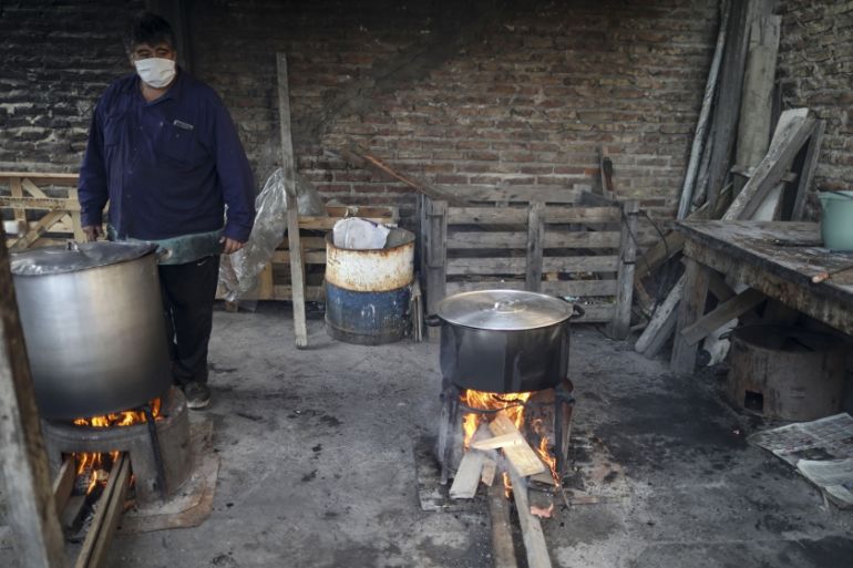 Avolunteer keeps an eye on pots filled with food cooking over an open fire at a soup kitchen, amid the new coronavirus pandemic, on the outskirts of Buenos Aires, Argentina. One of the world’s bigges