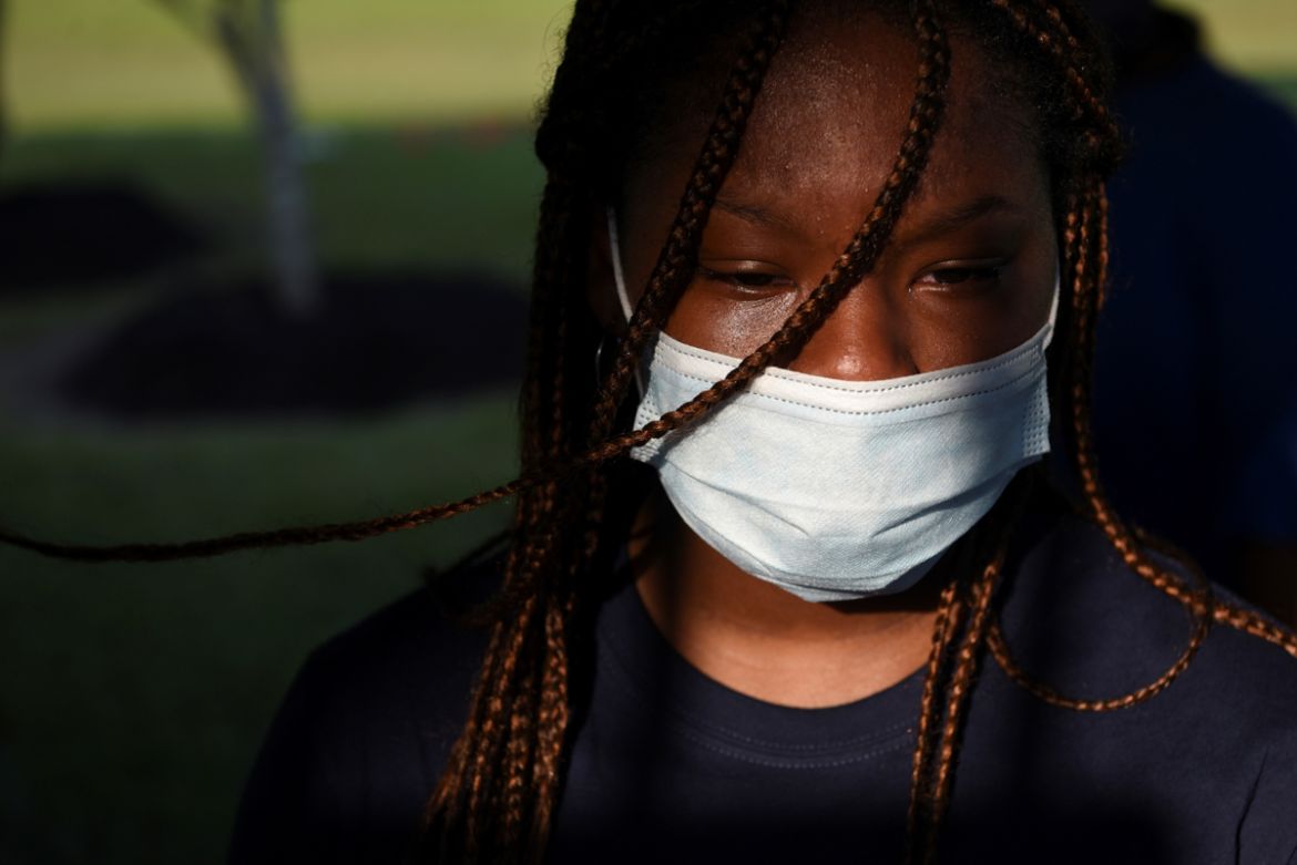 A young woman sheds a tear as people visit the gravesite of George Floyd, whose death in Minneapolis police custody has sparked nationwide protests against racial inequality, in Pearland, Texas, U.S.,