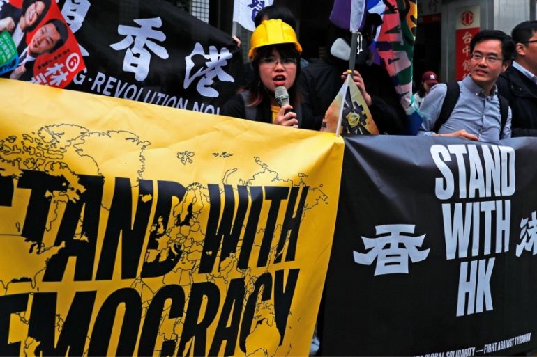 Hong Kong anti-government protesters hold a banner during a campaign event in Taipei