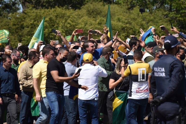 Brazil''s President Jair Bolsonaro greets supporters gathered outside the presidential palace in Brasilia, Brazil, Sunday, May 31, 2020. (AP Photo/Andre Borges)