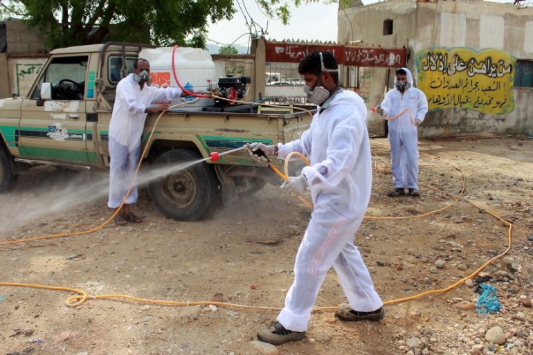 Yemeni sanitation workers, wearing protective gear, spray disinfectant in a neighbourhood in the northern Hajjah province on May 31, 2020, during the ongoing coronavirus pandemic. ESSA AHMED / AFP