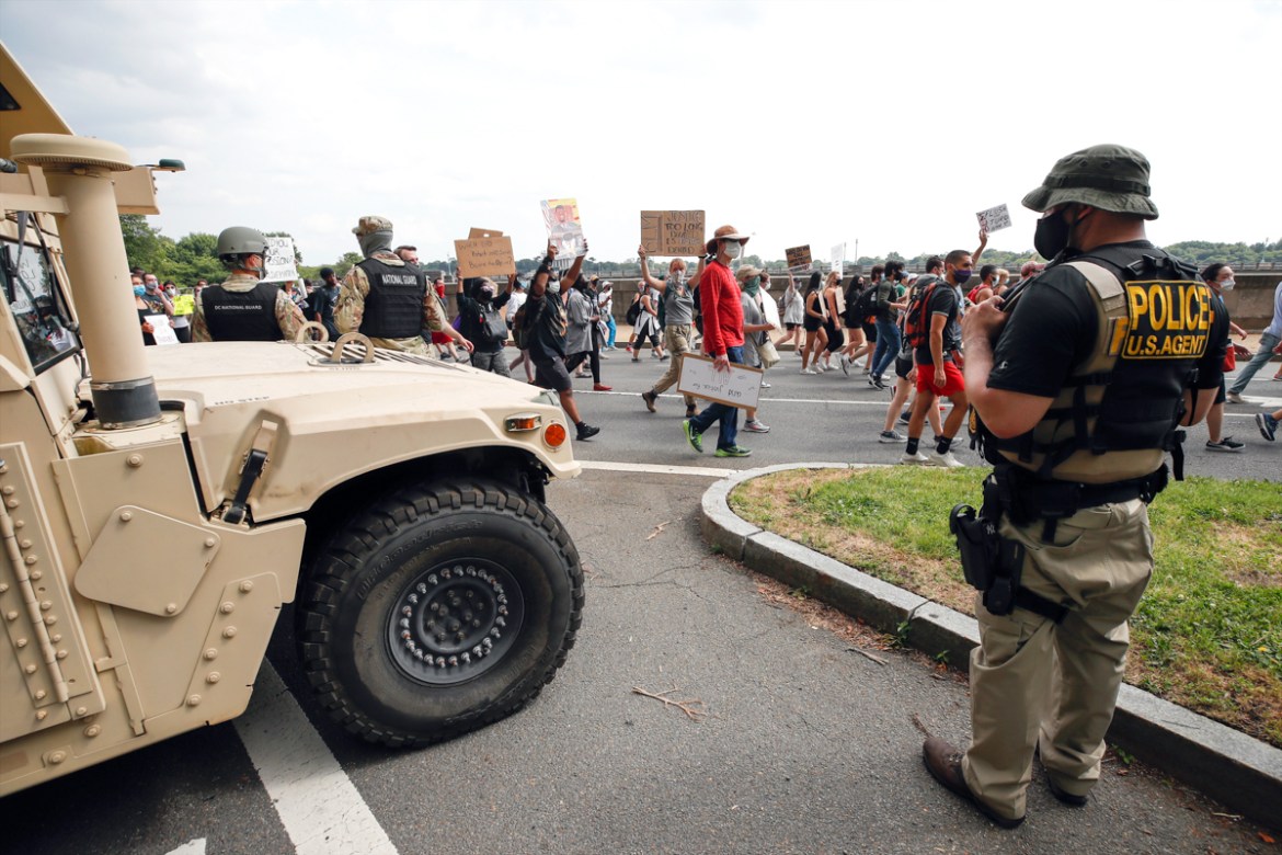 DC National Guard soldiers and other law enforcement personnel watch as demonstrators protest Saturday, June 6, 2020, along Independence Avenue in Washington, over the death of George Floyd, a black m