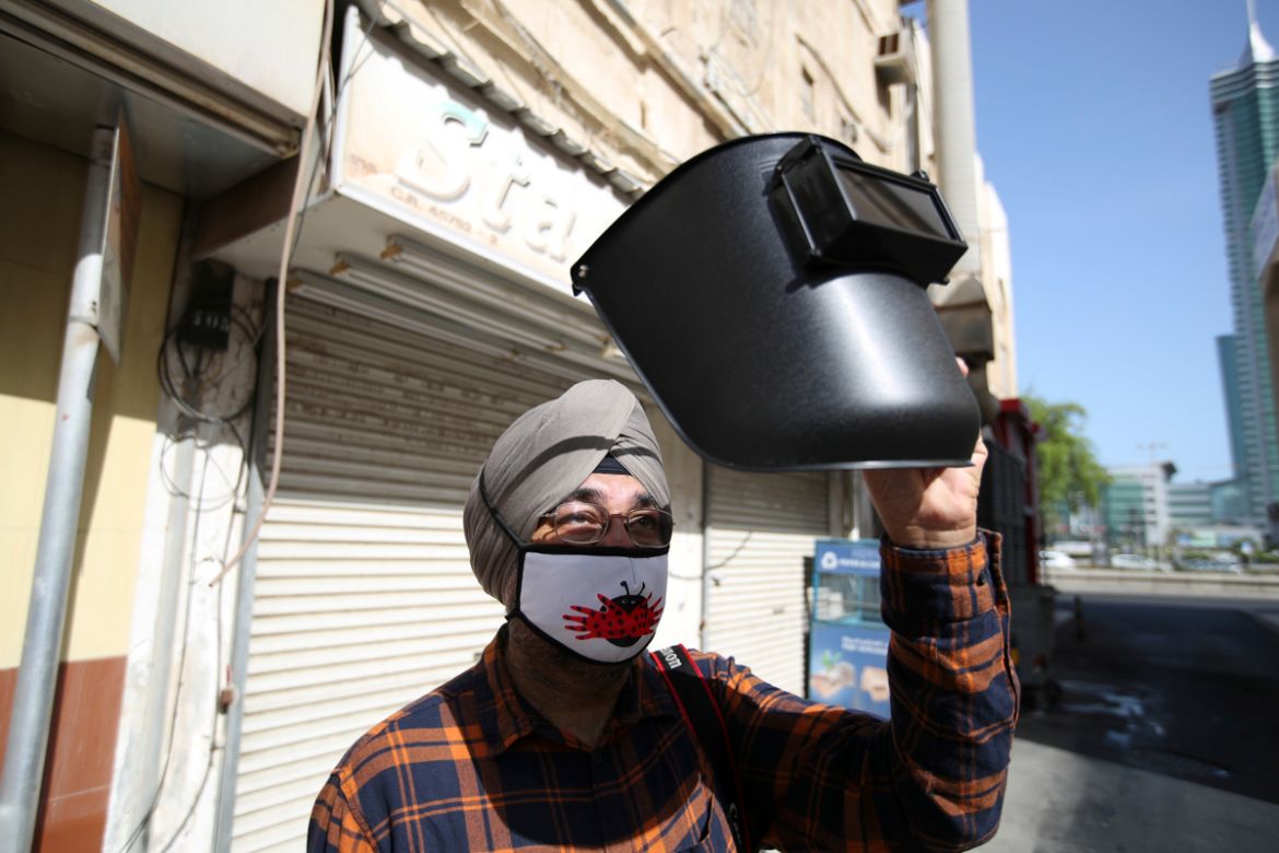 A man wearing a protective face mask uses a welding helmet as a protection to watch the annular solar eclipse, in Manama, Bahrain, June 21, 2020. REUTERS/Hamad I Mohammed