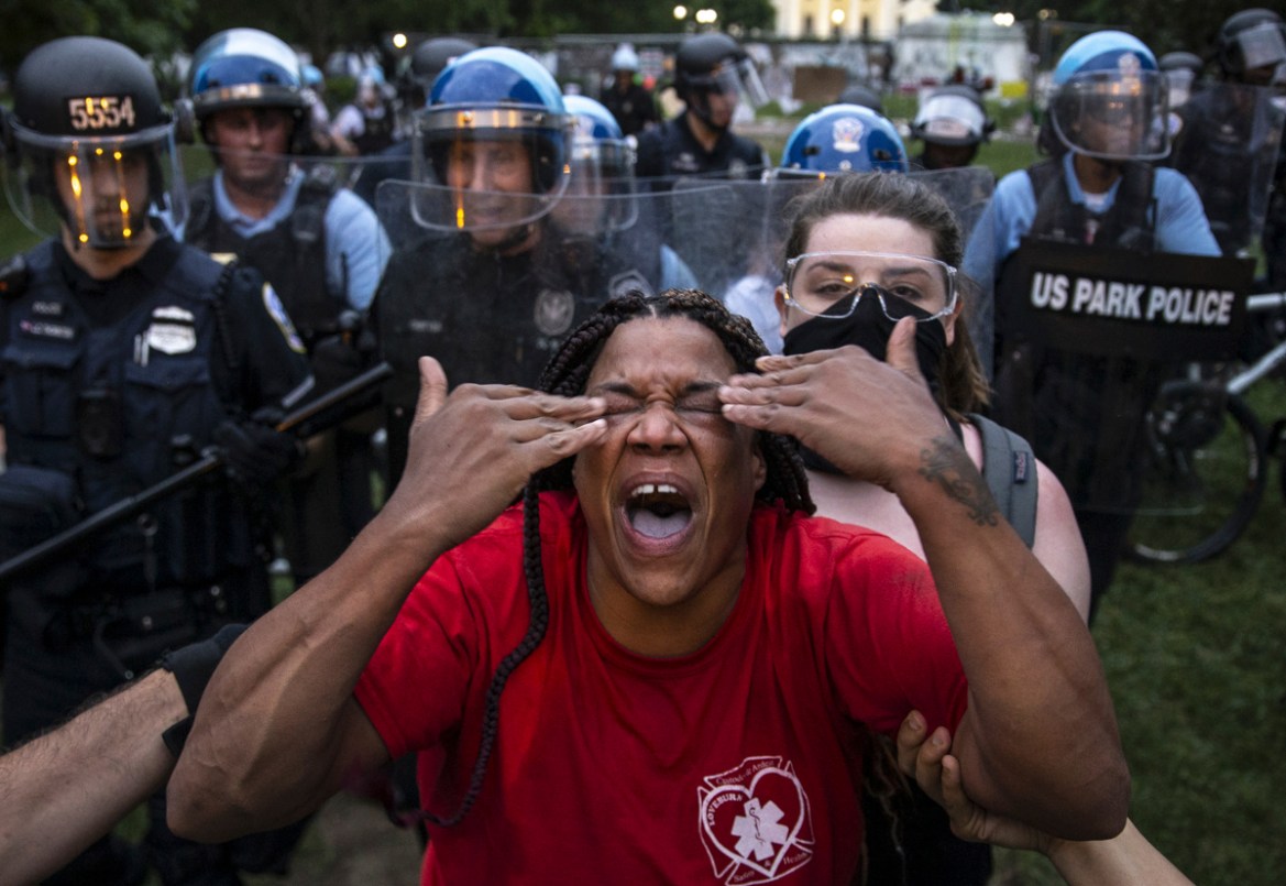WASHINGTON, DC - JUNE 22: A woman reacts to being hit with pepper spray as protesters clash with U.S. Park Police after they attempted to pull down the statue of Andrew Jackson in Lafayette Square nea