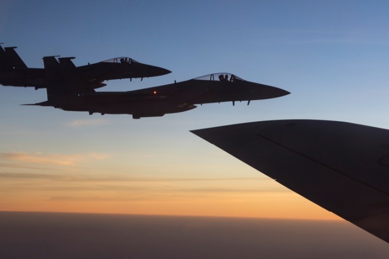 U.S. F-15C Eagles fly on the wing of a 28th Expeditionary Air Refuelling Squadron KC-135 Stratotanker during a combat air patrol mission over an undisclosed location in Southwest Asia