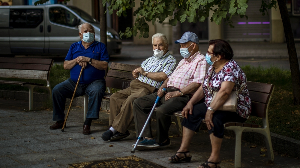 Elder people wearing face masks sit on a bench in a square in Barcelona, Spain, Sunday, May 31, 2020. Spanish Prime Minister Pedro SÃ¡nchez says he will ask Spain's Parliament for a final two-week ext