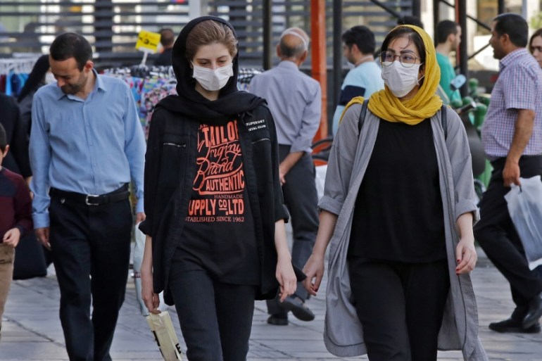 Iranians, some wearing face masks, walk along a street in the capital Tehran on June 3, 2020, amid the novel coronavirus pandemic crisis. - The spread of novel coronavirus has accelerated again this m