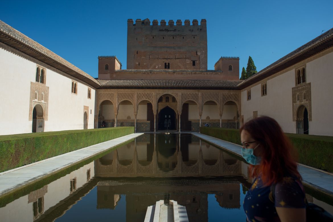 A tourist visits the Patio de Arrayanes at the Alhambra in Granada on June 17, 2020, on the day it reopen to the public after three months of closure due to the coronavirus pandemic. (Photo by JORGE G