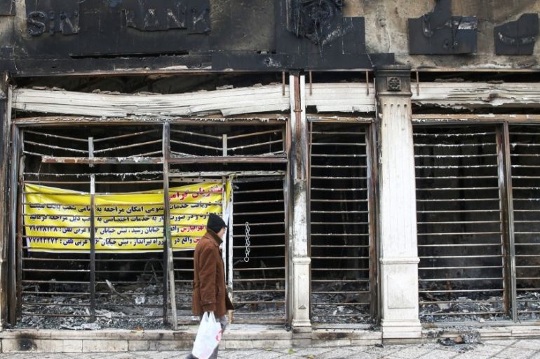 A man walks past the ruins of a burnt bank, after protests against increased fuel prices, in Tehran, Iran November 20, 2019. Picture taken November 20, 2019. Nazanin Tabatabaee/WANA