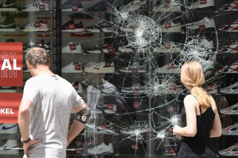 People look on a destroyed shop window of a shoe store in Stuttgart, southern Germany on June 21, 2020. Hundreds of people ran riot in Stuttgart''s city centre in the early hours of Sunday, June 21, 20