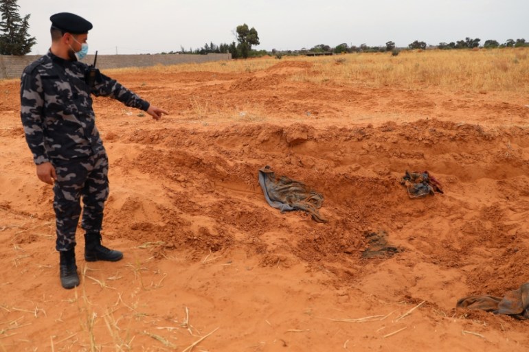 A member of security forces loyal to Libya''s internationally recognised government points to a mass grave, according to Libya''s Internationally recognised government officials, in Tarhouna city
