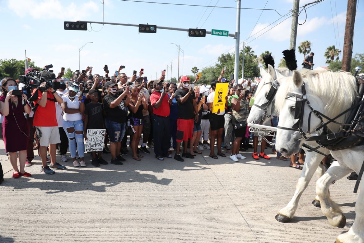 HOUSTON, TEXAS - JUNE 09: People watch as the horse drawn hearse containing the remains of George Floyd makes its way to the Houston Memorial Gardens cemetery on June 9, 2020 in Houston, Texas. Floyd