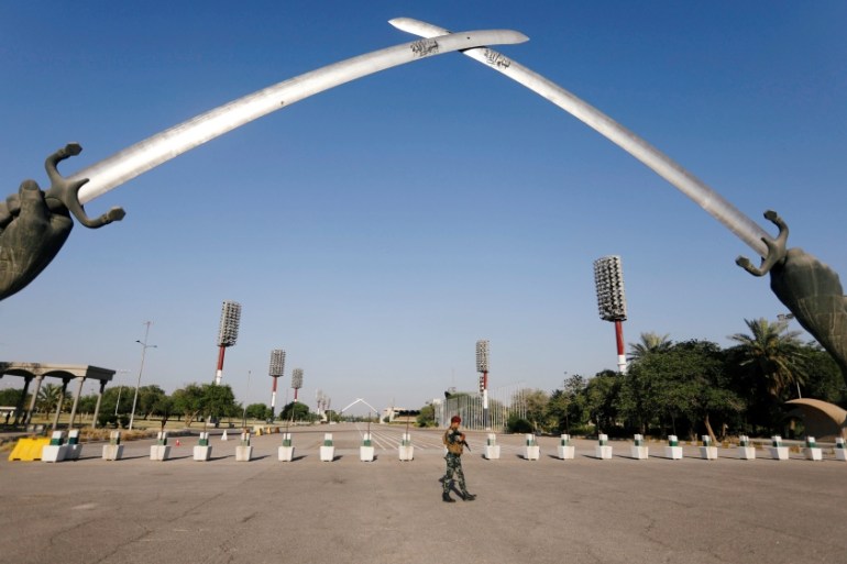 An Iraqi security officer walks near the "Arch of Victory" memorial in the Green Zone of Baghdad