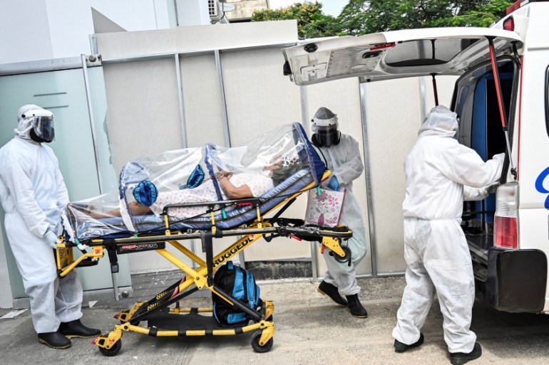 Health workers move a recovered novel coronavirus patient from the Versalles clinic to her home on June 24, 2020, in Cali, Colombia. Colombia extended its quarantine Tuesday until July 15, as its COVI