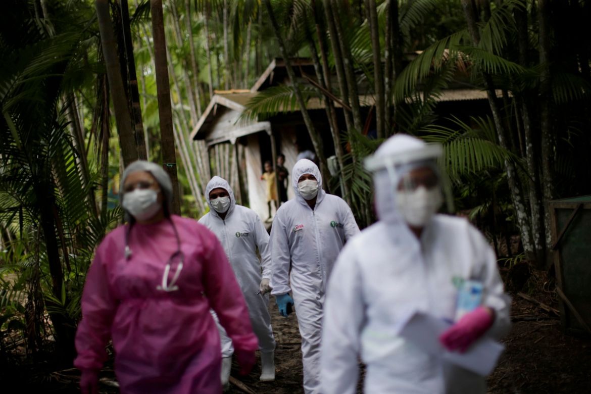 Healthcare workers walks in the riverside community Pinheiro, as they visit riverside communities to check on residents during the coronavirus disease (COVID-19) outbreak, in the municipality of Porte