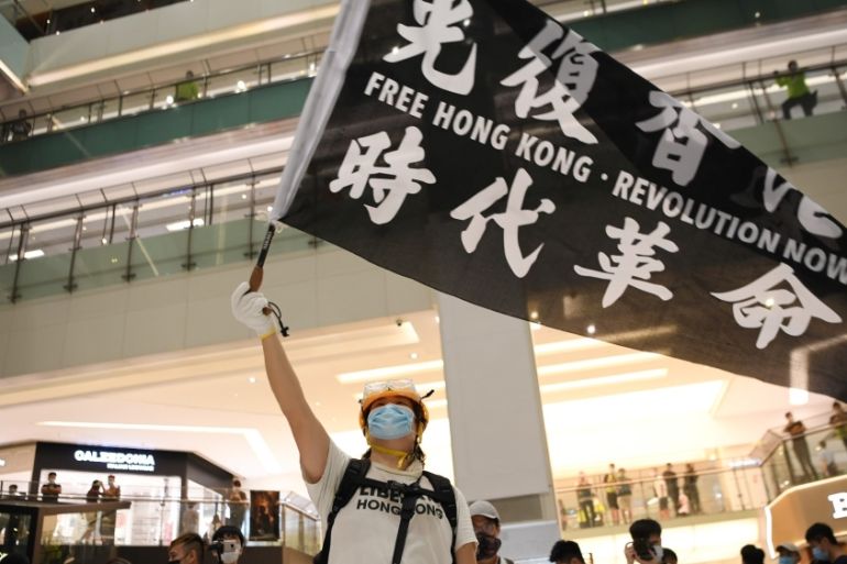 Pro-democracy protesters waves a banner during a protest at the New Town Plaza mall in Sha Tin in Hong Kong