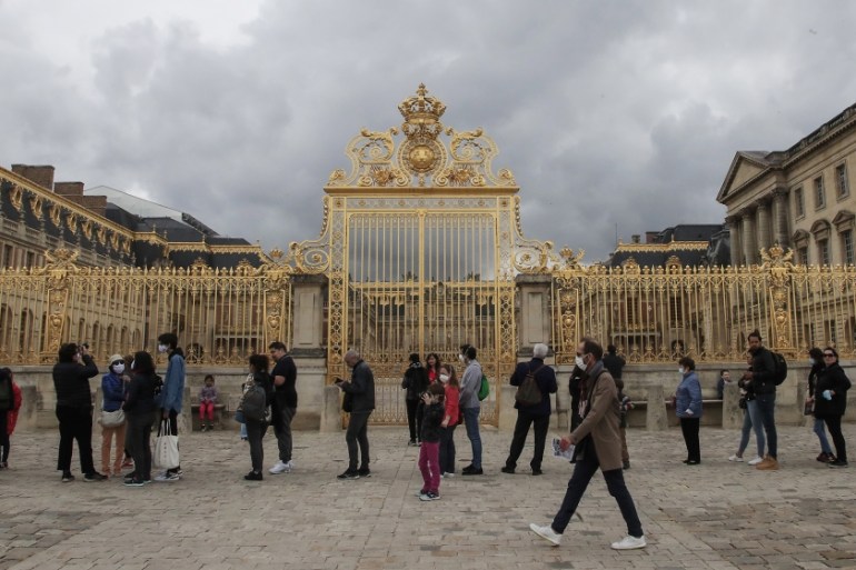 People lining up along the Gate of Honor to visit the Chateau de Versailles, west Paris, Sunday, June 7, 2020. The Chateau de Versailles was reopened on June 6, after Covid-19 closure. (AP Photo/Miche