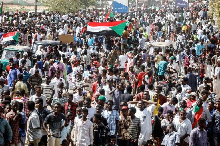 Civilians gather as members of Sudanese pro-democracy protest on the anniversary of a major anti-military protest, as groups loyal to toppled leader Omar al-Bashir plan rival demonstrations in Khartou
