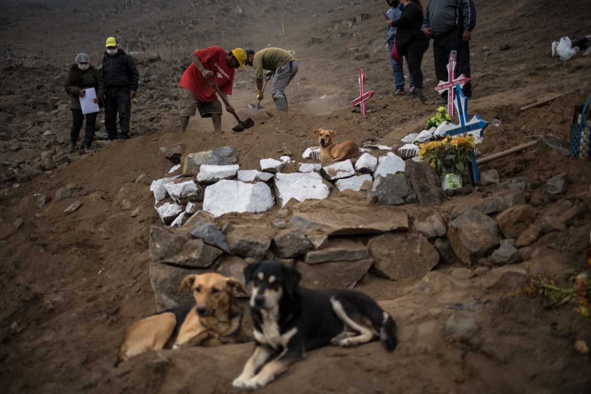 Cemetery workers shovel over the tomb of Romulo Huallpatuero, 50, who died of COVID-19, at the Nueva Esperanza cemetery on the outskirts of Lima, Peru, Tuesday, May 26, 2020. (AP Photo/Rodrigo Abd)