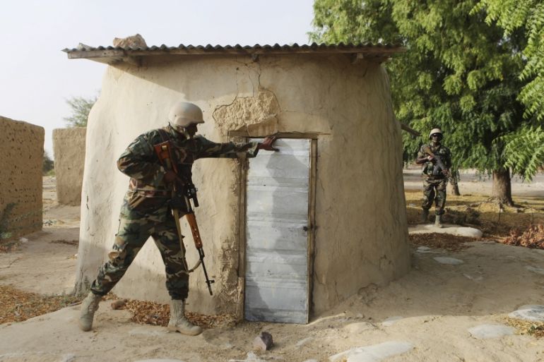 A Nigerien soldier checks a building while on patrol in Duji