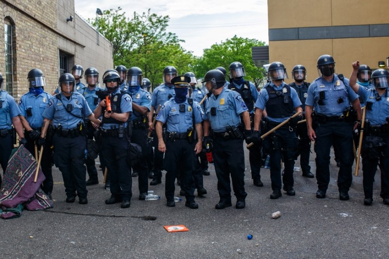 Minneapolise Police officers stand in a line while facing protesters demonstrating against the death of George Floyd outside the 3rd Precinct Police Precinct in Minneapolis, Minnesota. Members of the