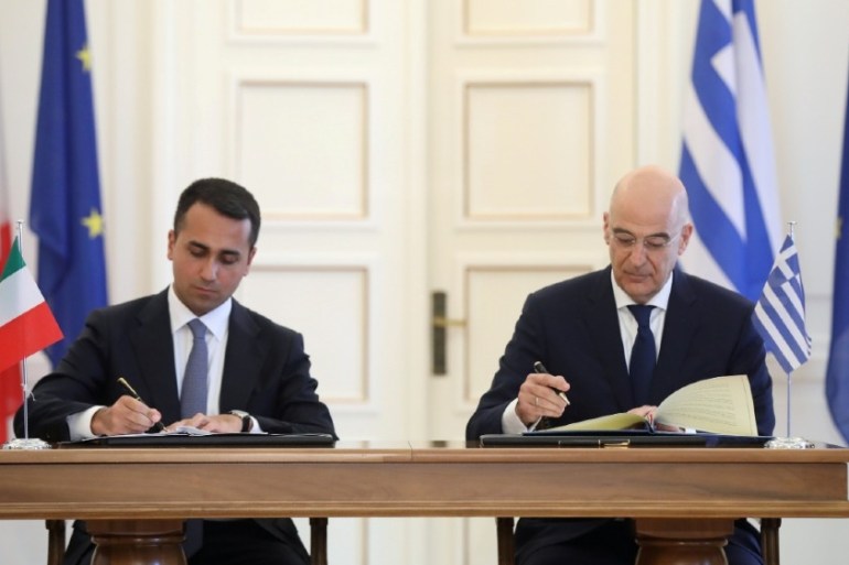Greek Foreign Minister Nikos Dendias and his Italian counterpart Luigi Di Maio sign an agreement following a meeting at the Foreign Ministry in Athens, Greece, June 9, 2020. REUTERS/Costas Baltas