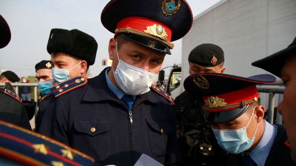 Law enforcement officers wearing face masks are seen on duty at a checkpoint on the outskirts of Almaty on March 19, 2020, after authorities locked down the city to contain the spread