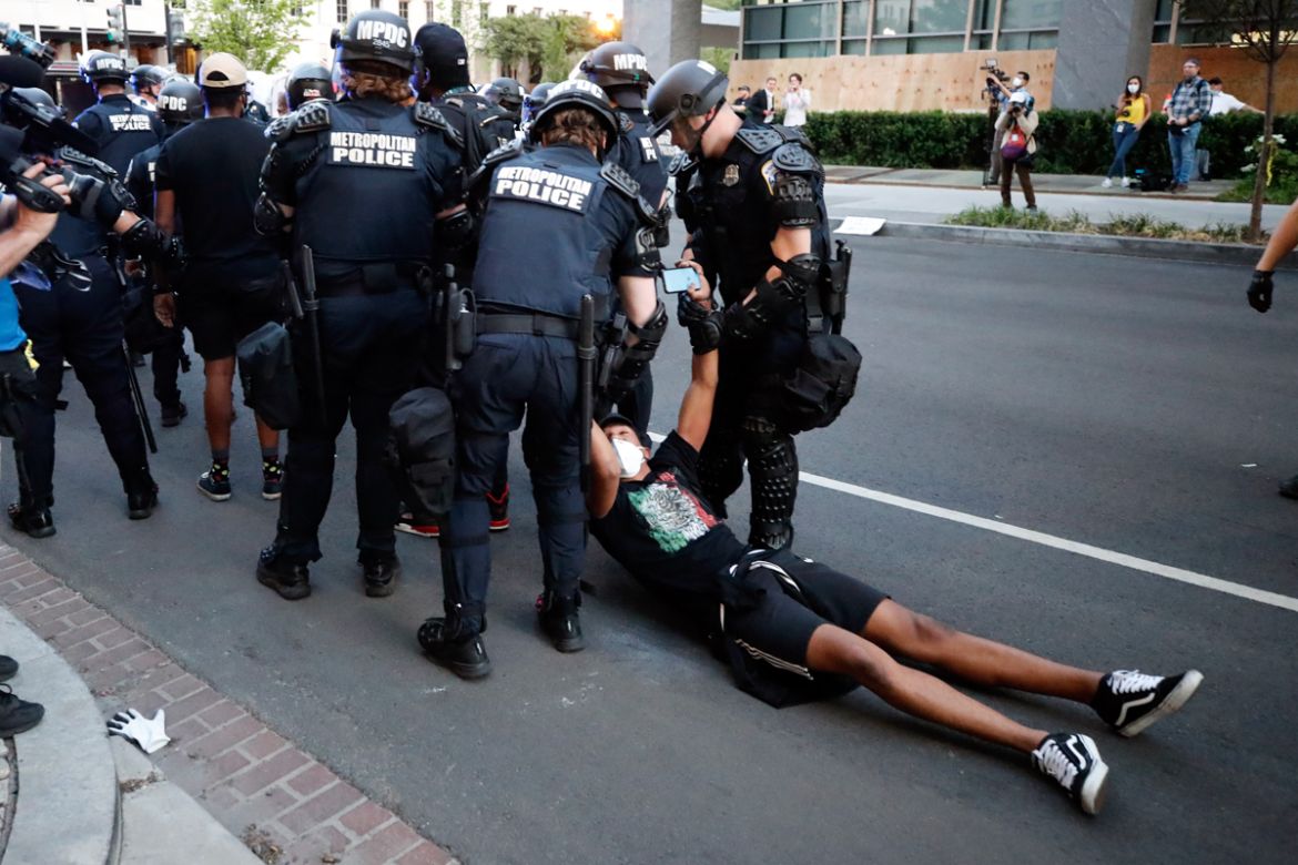 A demonstrator is taken into custody by police after a curfew took effect during a protest over the death of George Floyd, Monday, June 1, 2020, near the White House in Washington. Floyd died after be