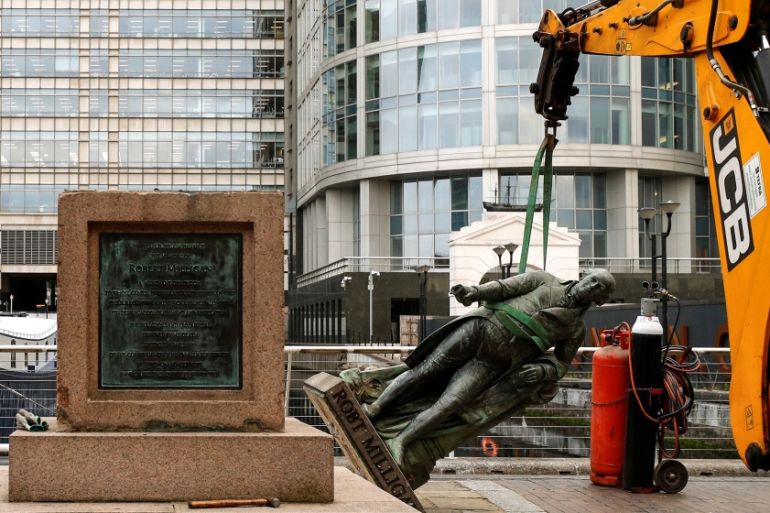 A statue of Robert Milligan is pictured being removed by workers outside the Museum of London Docklands near Canary Wharf, following the death of George Floyd who died in police custody in Minneapolis