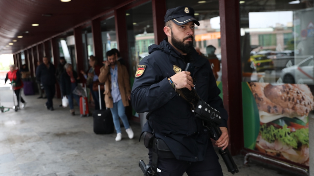 A Spanish National Police officer stands guard outside Atocha train station after it was reopened in Madrid
