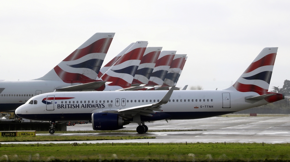 A British Airways plane taxis past tail fins of parked aircraft to the runway near Terminal 5 at Heathrow Airport in London, Britain March 14, 2020. REUTERS/Simon Dawso