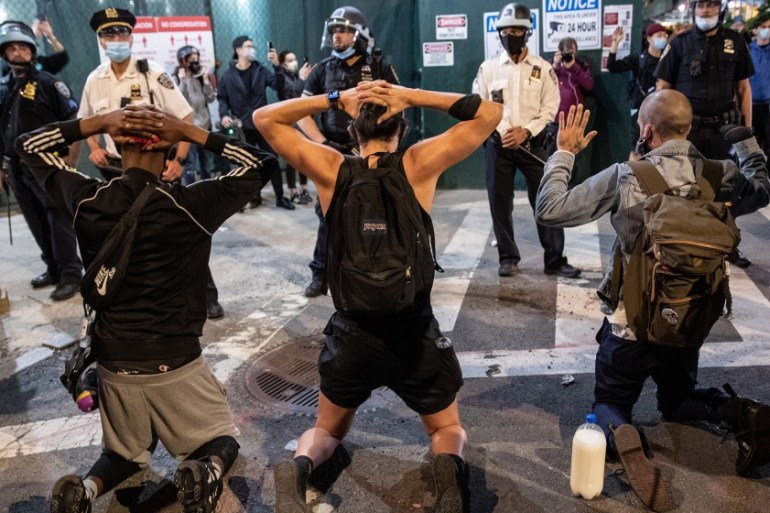 Protesters kneel in front of New York City Police during a march to honor George Floyd in Manhattan on May 31, 2020 in New York City. Protesters demonstrated for the fourth straight night after video