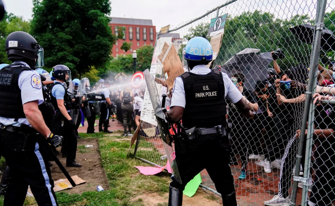 U.S. Park Police officers deploy pepper spray as they clash with protestors during an attempt to pull down the statue of U.S. President Andrew Jackson in the middle of Lafayette Park in front of the W