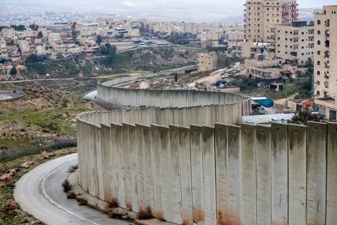 A picture taken on February 11, 2020 shows the Israeli settlement of Pisgat Zeev (L), built in a suburb of the mostly Arab east Jerusalem, and the Palestinian Shuafat refugee camp (R) behind Israel''s