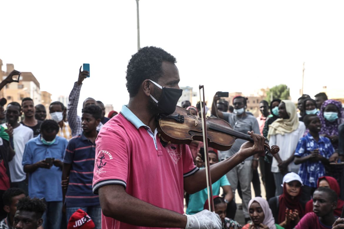epa08518739 A Sudanese protester wears a face mask as he plays revolutionary songs on a fiddle during a protest in Khartoum, Sudan, 30 June 2020. The protesters gathered on the 31st anniversary of the