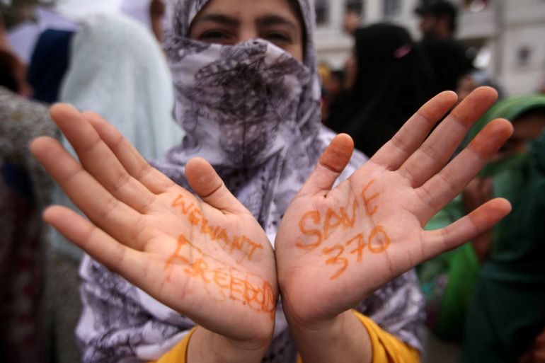 A Kashmiri woman shows her hands with messages at a protest after Friday prayers during restrictions after the Indian government scrapped the special constitutional status for Kashmir, in Srinagar Aug