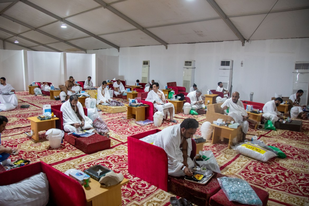 Muslim pilgrims receive food as they sit in a tent on the plains of Arafat during the annual Haj pilgrimage, amid the coronavirus disease (COVID-19) pandemic, outside the holy city of Mecca, Saudi Ara