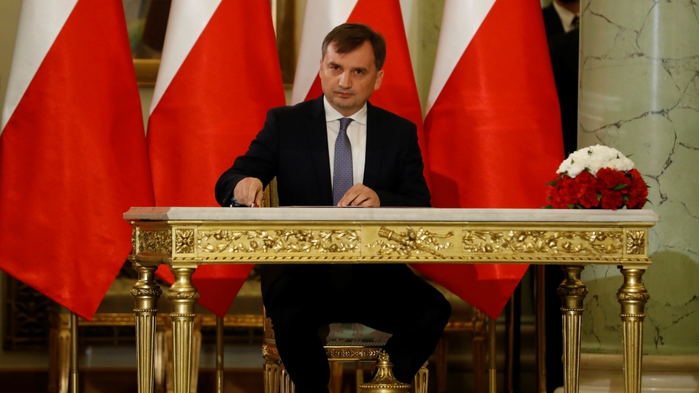 Zbigniew Ziobro signs documents after being designated as Minister of Justice, at the Presidential Palace in Warsaw