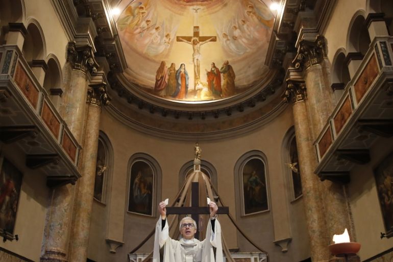 In this April 2, 2020 file photo, Don Angelo Riva celebrates a mass in an empty church in Carenno, Italy.