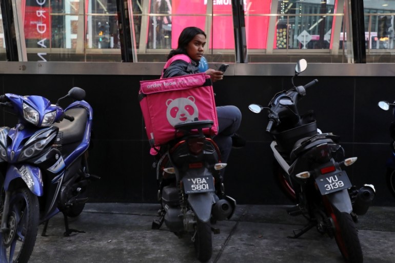 A Foodpanda rider waits for orders outside a restaurant, amid the coronavirus disease (COVID-19) outbreak in Kuala Lumpur