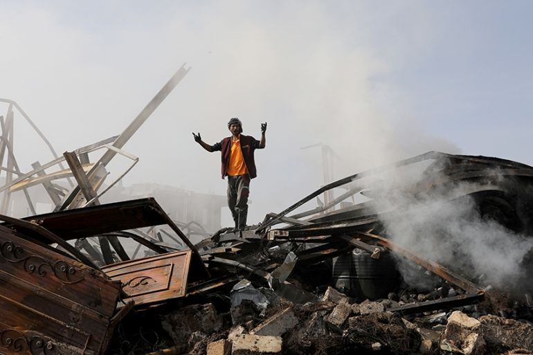 A worker reacts as he stands on the wreckage of a vehicle oil and tires store hit by Saudi-led air strikes in Sanaa, Yemen July 2, 2020. REUTERS/Khaled Abdullah