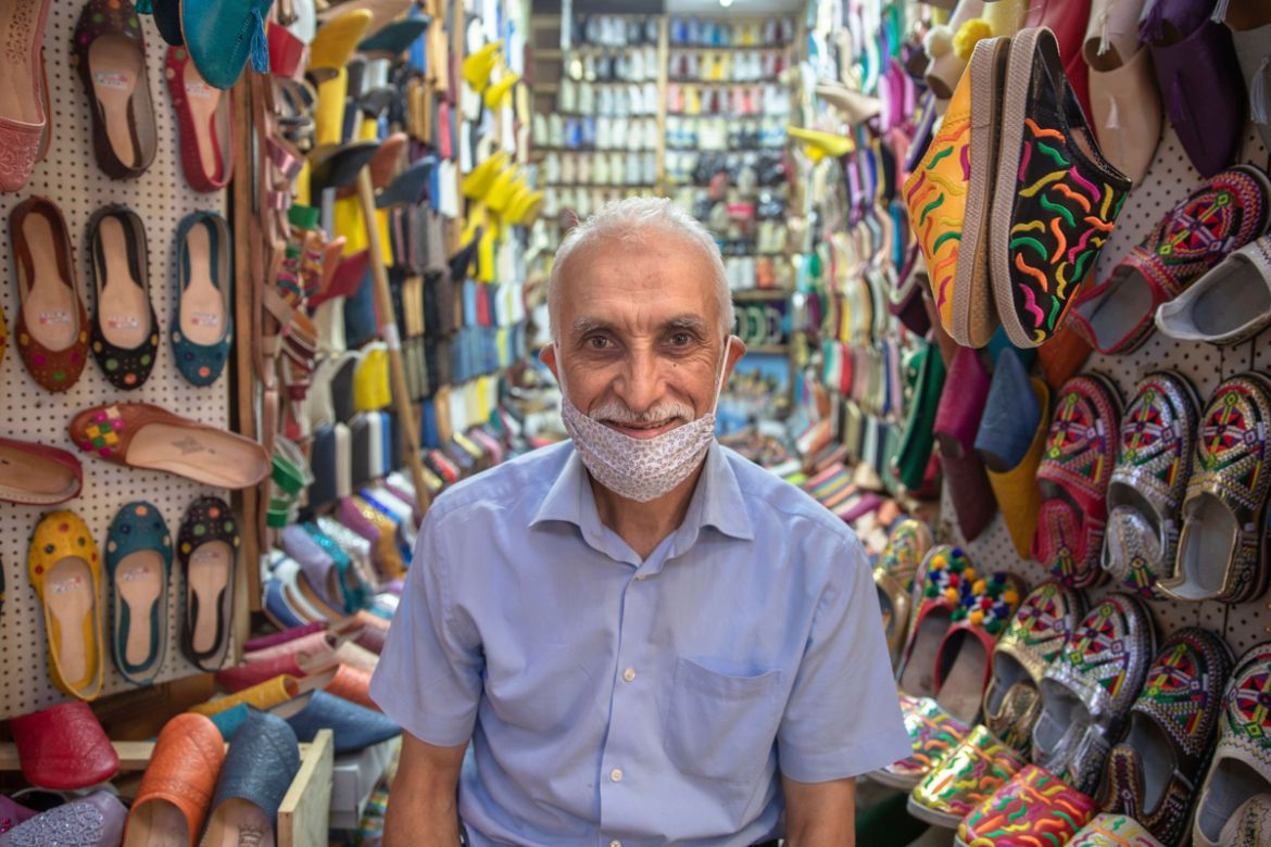 Brik Ait Qeddour poses for a photo at his reopened shop in the Medina of Rabat after lockdown measure were lifted, in Morocco, Friday, June 26, 2020. Moroccans are re-experiencing a taste of the life