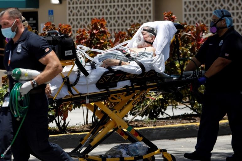 Emergency Medical Technicians (EMT) leave with a patient at Hialeah Hospital where the coronavirus disease (COVID-19) patients are treated