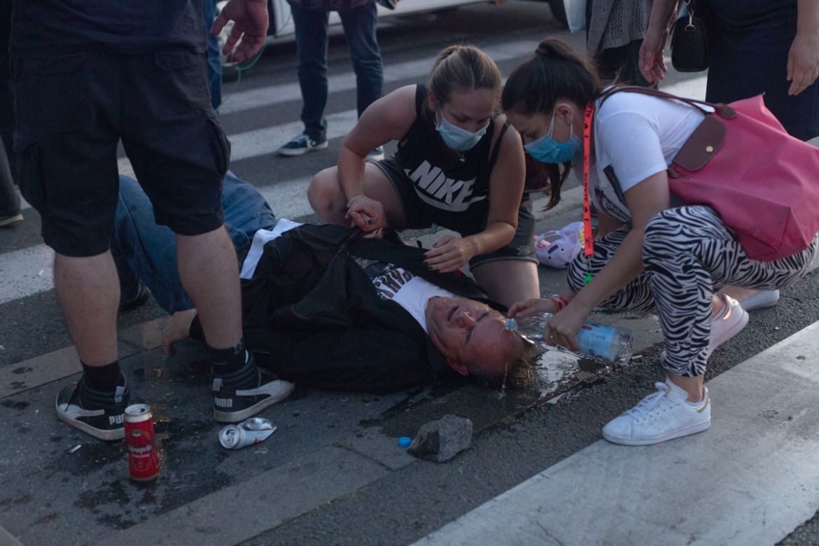 People tend to an injured man during a protest in Belgrade, Serbia, Wednesday, July 8, 2020. Police have fired tear gas at protesters in Serbia''s capital during the second day of demonstrations agains