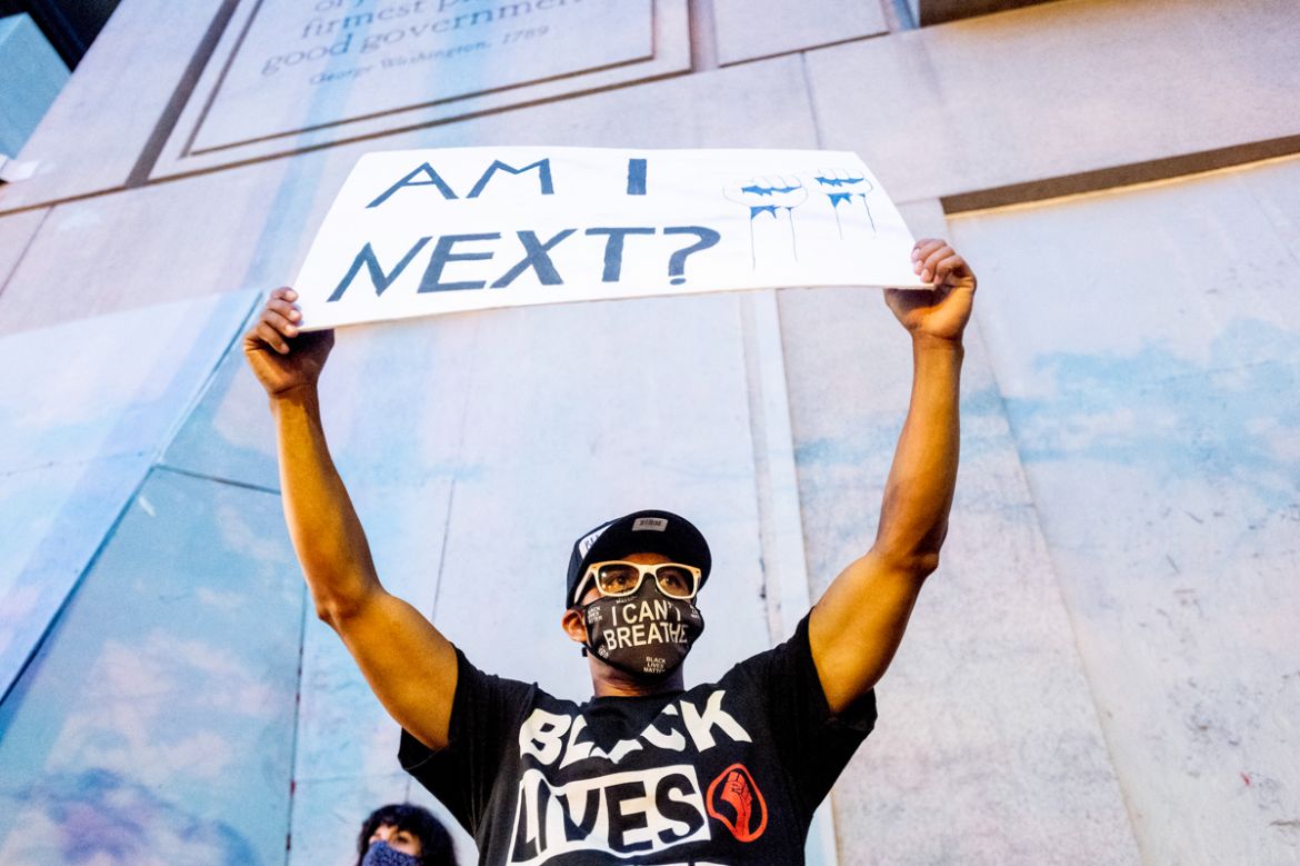 Romeo Ceasar holds a sign during a Black Lives Matter protest in Portland, Ore. July 20, 2020. (AP Photo/Noah Berger)