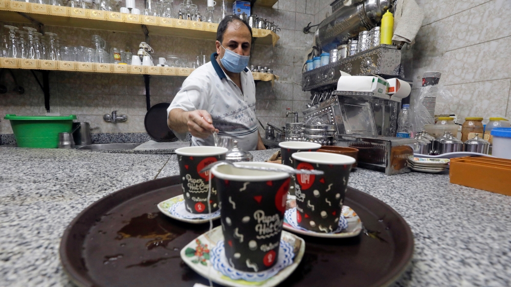 A waiter serves customers in a cafe after months of lockdown, following the outbreak of the coronavirus disease (COVID-19), in Cairo