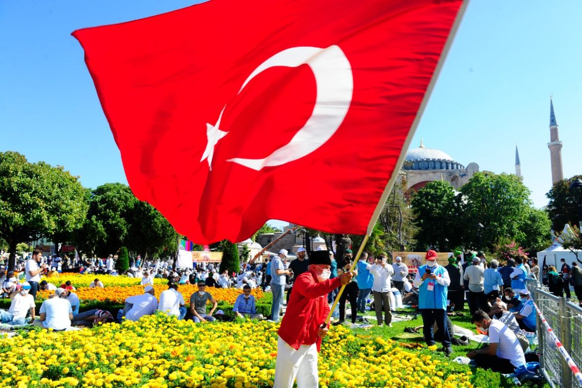 A man waves a Turkish flag outside TURKEY HAGIA SOPHIA