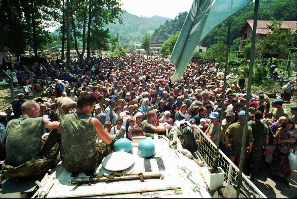 July 13, 1995 file photo, Dutch U.N. peacekeepers sit on top of an armored personnel carrier as Muslim refugees from Srebrenica, eastern Bosnia, gather in the nearby village of Potocari. A Dutch appea