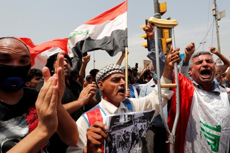 Iraqi demonstrators gesture as they attend the funeral of a protester, who was killed last night during the ongoing anti-government protest due to poor public services at Tahrir Square in Baghdad